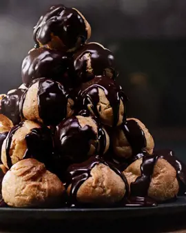 Profiterole tower with vanilla cream and chocolate sauce