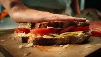 Sandwich pressed down by a hand